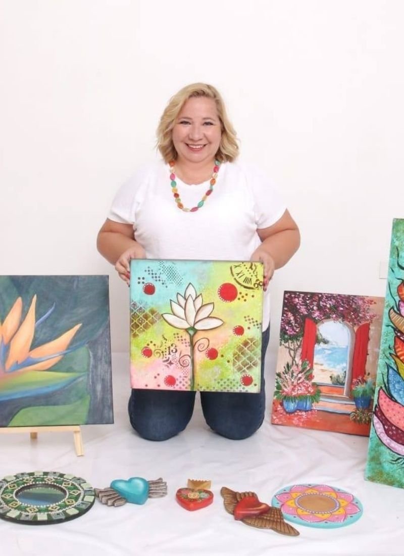 Viviana Nuñez Plaz, fundadora de La Casita del Arte, posando junto a sus obras de técnica mixta